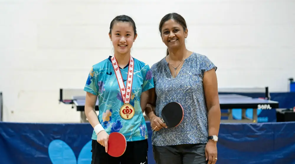 Anita Roy with champion Alexus Lee holding a table tennis paddle